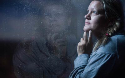 Depressed woman looks out window