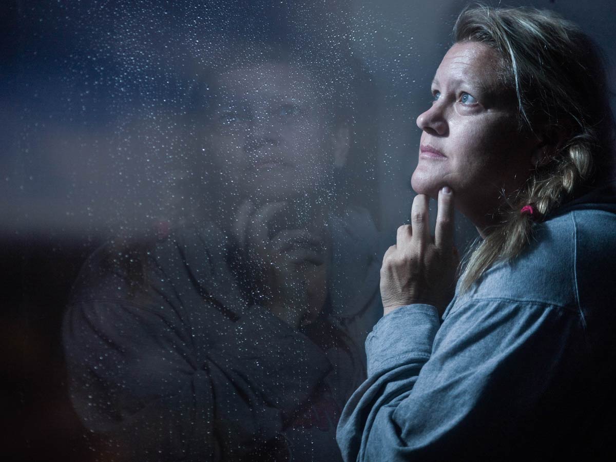 Depressed woman looks out window