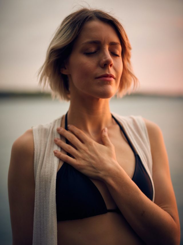 IMAGE: A young woman holding her chest taking a deep breath
