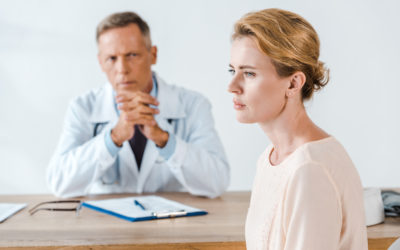 woman sitting near doctor in white coat