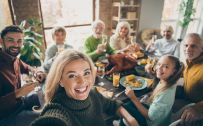 Photo of big family sit feast dishes table around roasted turkey multi-generation, relatives making group selfies raising wine glasses juice in living room indoors