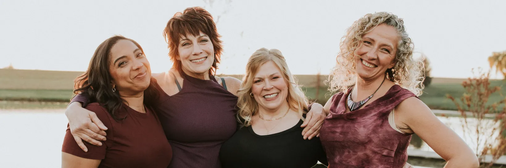 Four smiling women stand together