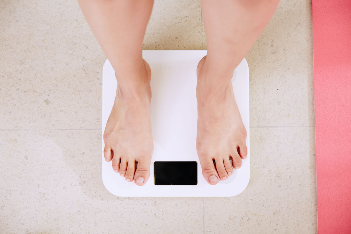 Woman stands on weight scales