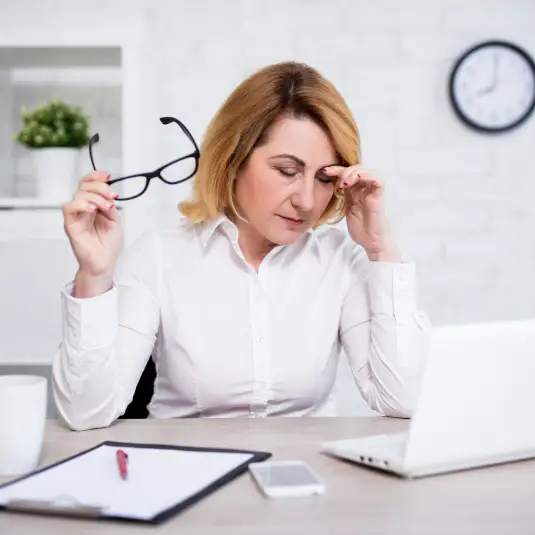 Middle aged woman struggling to concentrate at desk